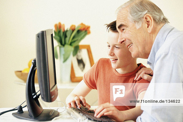 Grandfather and grandson using computer
