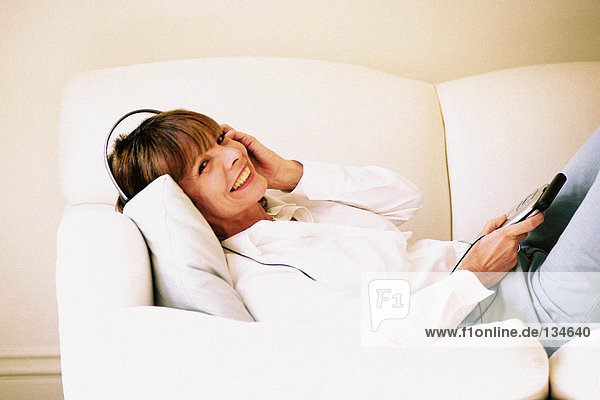 Woman listening to music on sofa