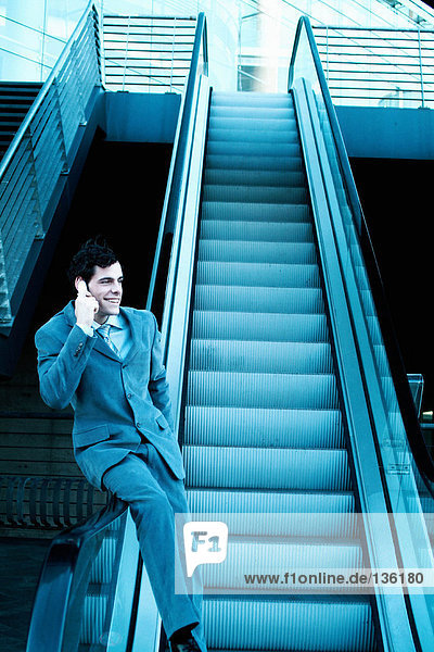 Geschäftsmann auf einer Rolltreppe sitzend