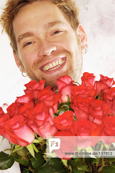 Lächelnder Mann mit roten Rosen