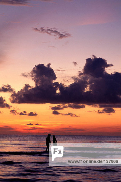 Couple in sea at sunset