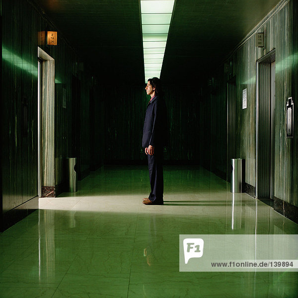 Man standing in empty corridor