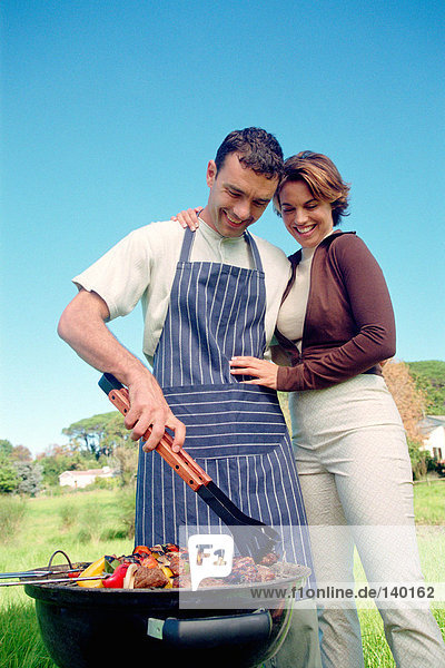 Couple cooking food on barbeque