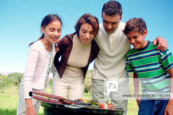 Family looking at food on barbeque