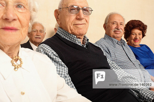 Ältere Menschen sitzend mit Blick auf die Kamera