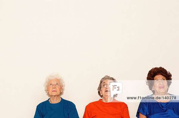 Drei ältere Frauen  die nach oben schauen.