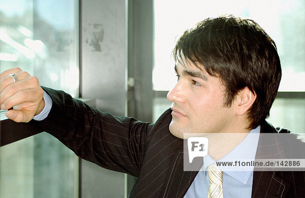 Businessman leaning against window