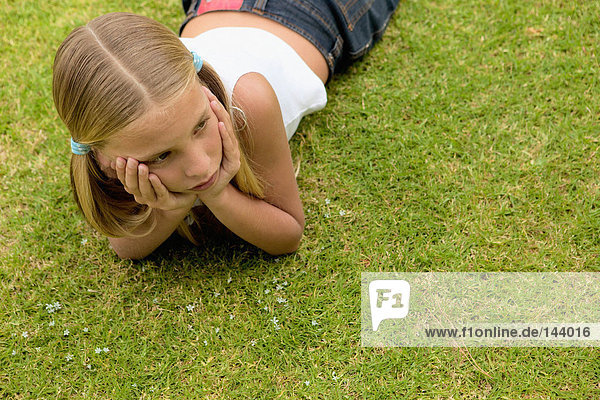 Junges Mädchen auf dem Rasen liegend