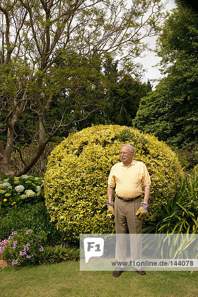 Ein älterer Mann stand in einem Garten.