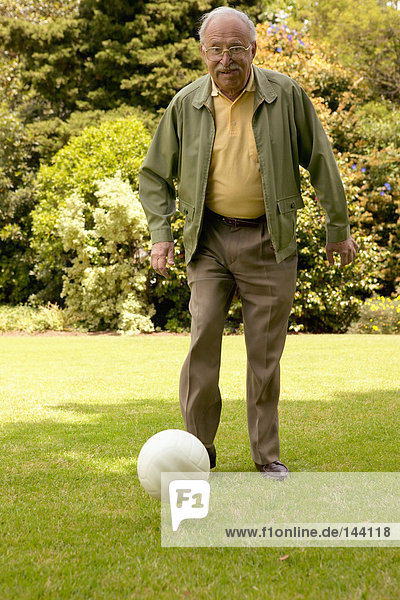 Älterer Mann tritt Fußball