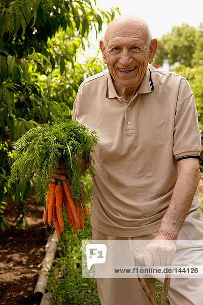 Porträt eines älteren Mannes mit einem Haufen Karotten
