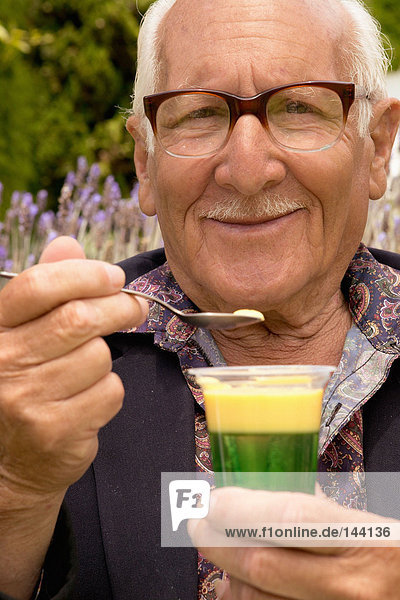 Ein älterer Mann hält ein Dessert.