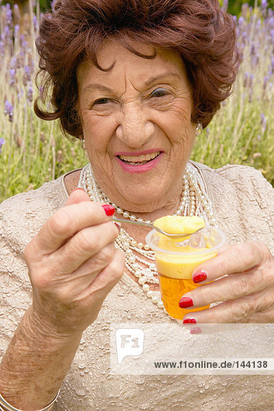 Eine ältere Frau hält ein Dessert.