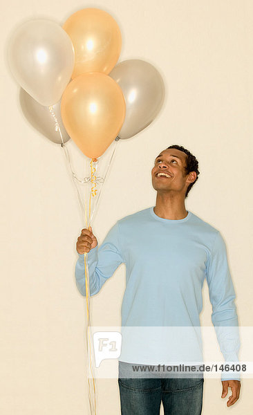 Mann mit einem Haufen Luftballons