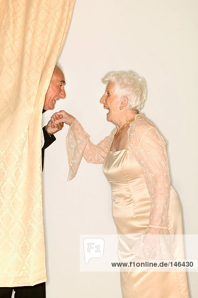 Mann  der eine ältere Frauenhand küsst.