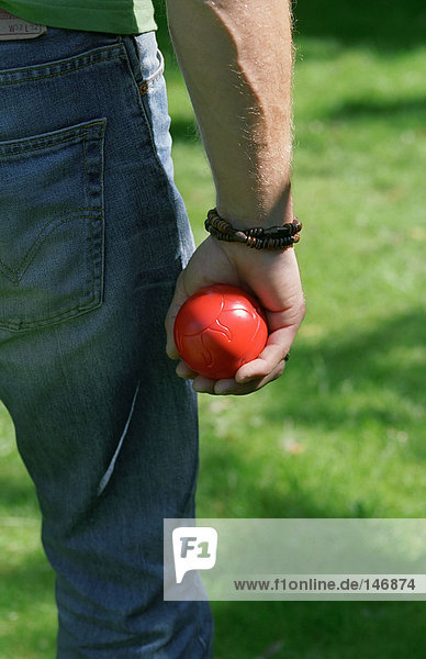 Man holding red ball in his hand.