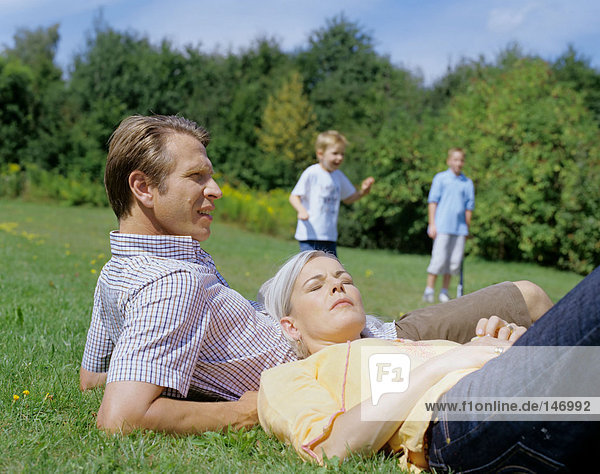 Parents relax while boys play.