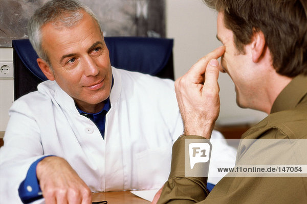 Mann im Gespräch mit einem Arzt