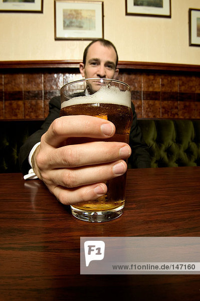 Businessman holding a pint of lager