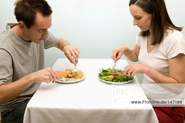 Couple having contrasting meals