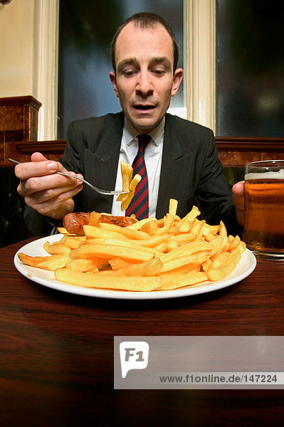 Businessman having chips and sausage