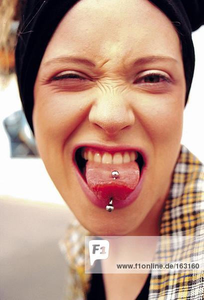 Porträt von Teenagerin pierced Zunge heraus