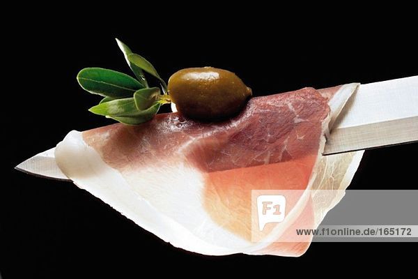 Parmaschinken und Oliven auf Messer