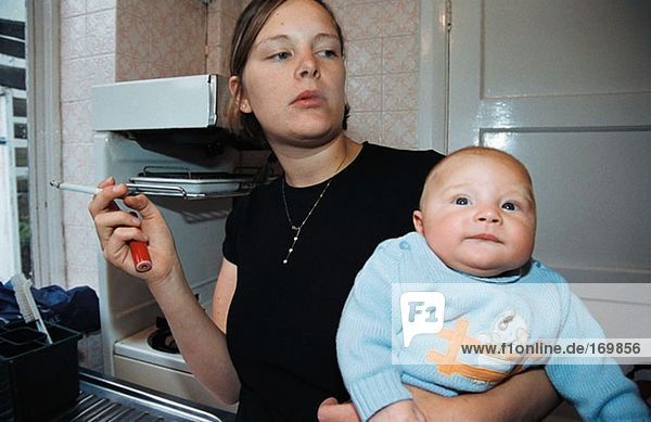 Frau raucht in der Nähe von Baby