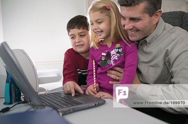 Father and children using computer