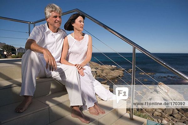 Mature couple sitting by the sea