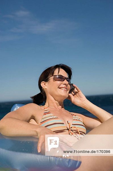 Frau auf Schlauchboot mit Handy