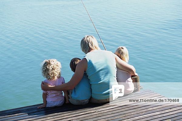 Vater mit Kindern am Steg