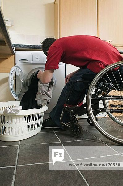 Behinderter Mann beim Wäschewaschen