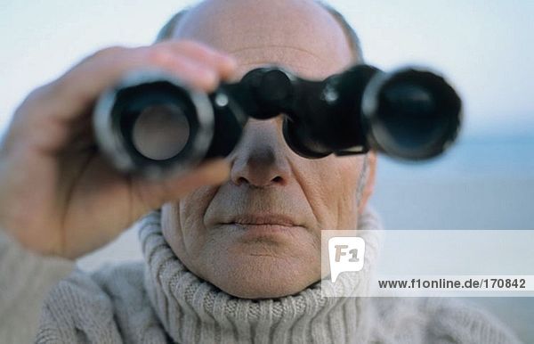 Senior man using binoculars
