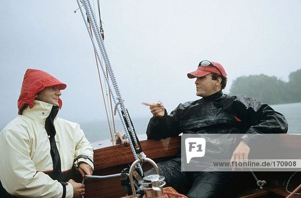 Zwei Männer  die auf einem Boot sitzen und reden.