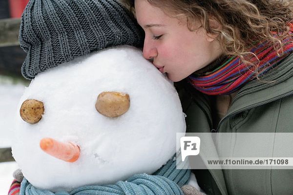 Woman kissing a snowman