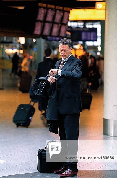 Businessman checking time at airport