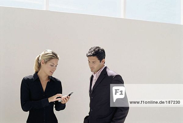 Businesswoman showing businessman her phone