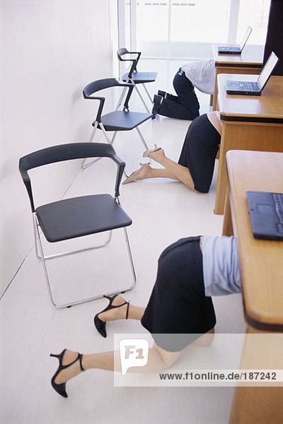 Office workers crawling under their desks