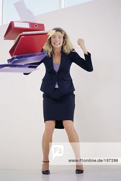 Angry businesswoman throwing folders