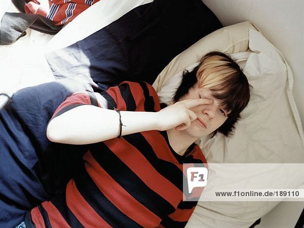 Teenager-Junge auf dem Bett liegend