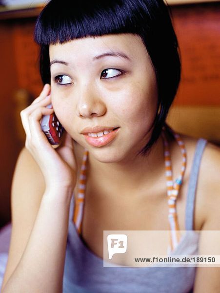 Teenage girl using cellular telephone