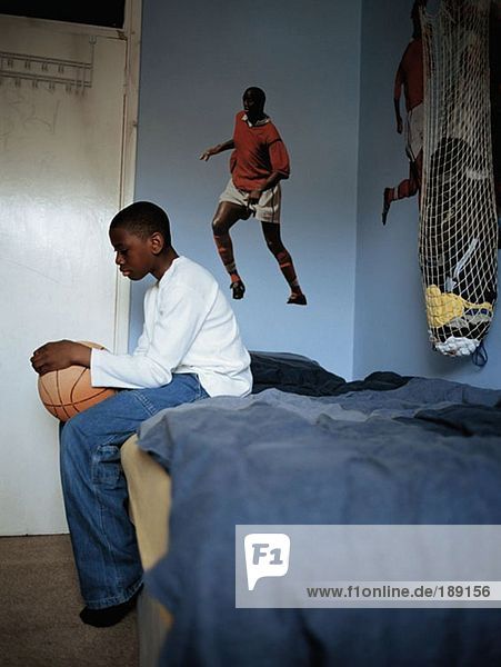 Junge mit Basketball im Schlafzimmer