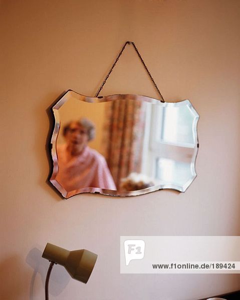 Spiegelung der älteren Frau im Spiegel