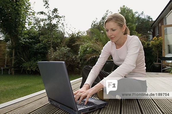 Woman using laptop in the garden