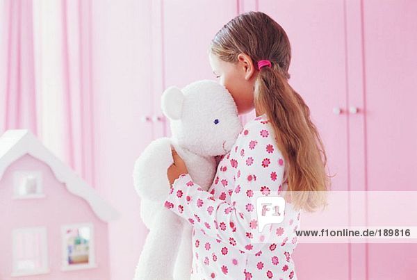 Mädchen umarmt ihren Teddybären