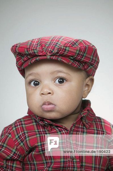 Süßes Baby mit flacher Mütze