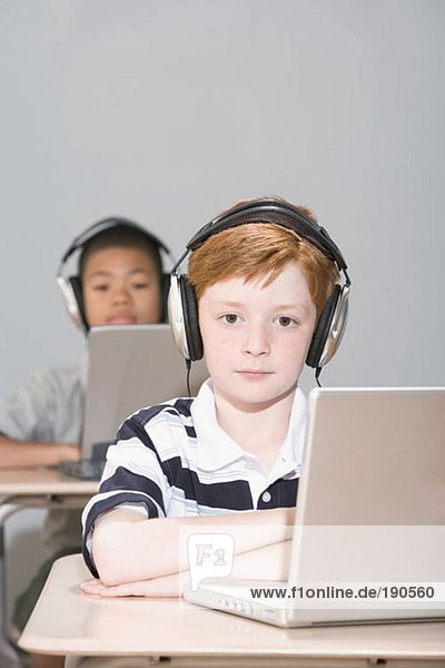 Jungen mit Laptops und Kopfhörern