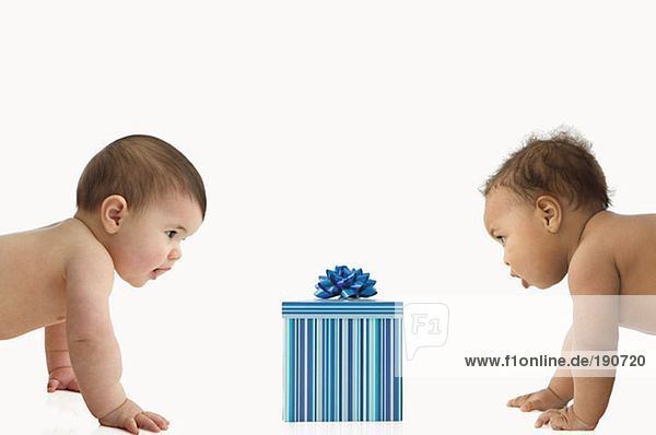 Zwei Babys mit einer Geschenkbox