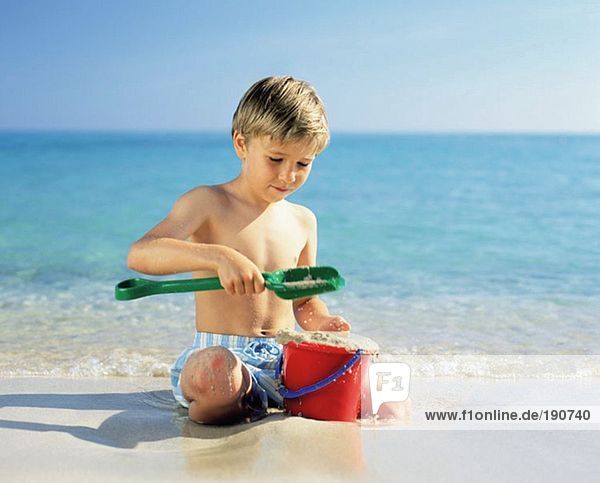 Boy playing with wet sand